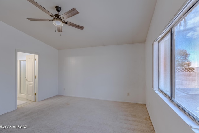unfurnished room with a wealth of natural light, vaulted ceiling, ceiling fan, and light colored carpet