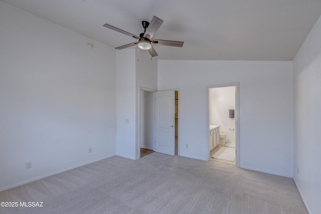 unfurnished bedroom with connected bathroom, vaulted ceiling, ceiling fan, and light colored carpet