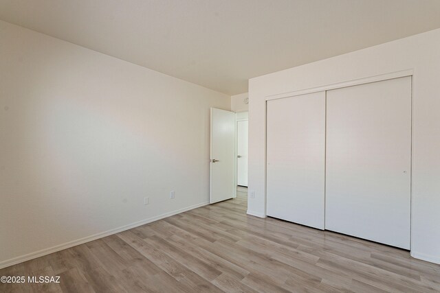 3856 W Argo St, Tucson, AZ 85742 - unfurnished bedroom with light wood finished floors, a closet, and baseboards