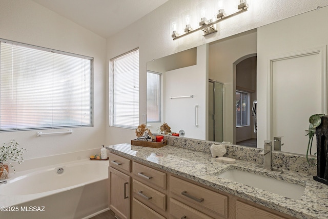 full bath with vaulted ceiling, a garden tub, vanity, and a shower stall