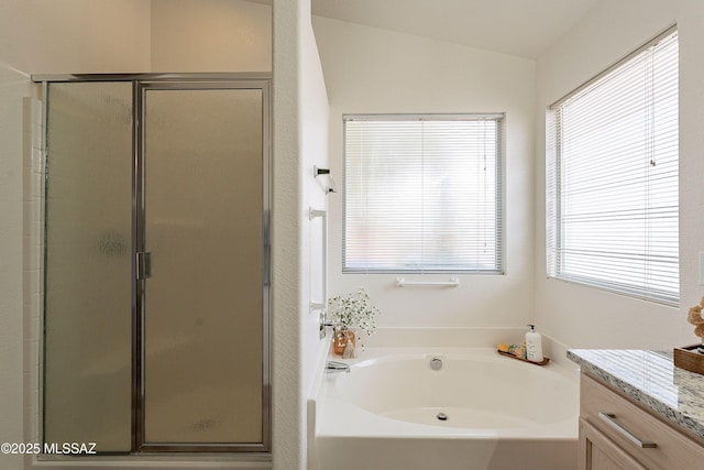 bathroom with a shower stall and a garden tub