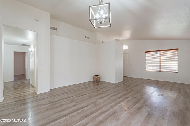 unfurnished room featuring vaulted ceiling, visible vents, light wood-style floors, and a notable chandelier