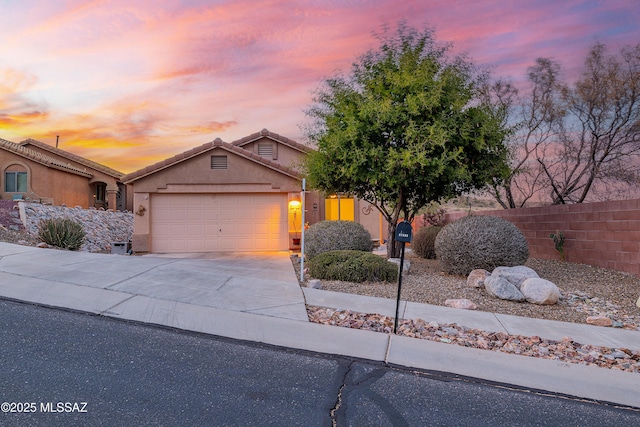 61080 Halter Pl, Saddlebrooke, AZ 85739 - view of front of house featuring fence, a tiled roof, a garage, concrete driveway, and stucco siding