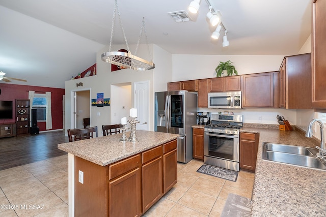 61080 Halter Pl, Saddlebrooke, AZ 85739 - kitchen featuring a sink, stainless steel appliances, a center island, and light tile patterned floors