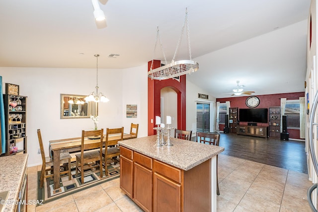 61080 Halter Pl, Saddlebrooke, AZ 85739 - kitchen featuring arched walkways, lofted ceiling, light countertops, and light tile patterned floors