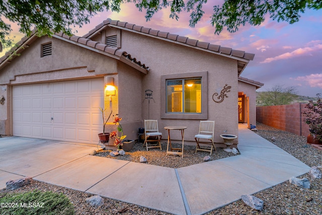 61080 Halter Pl, Saddlebrooke, AZ 85739 - mediterranean / spanish-style home featuring stucco siding, fence, a tiled roof, driveway, and a garage
