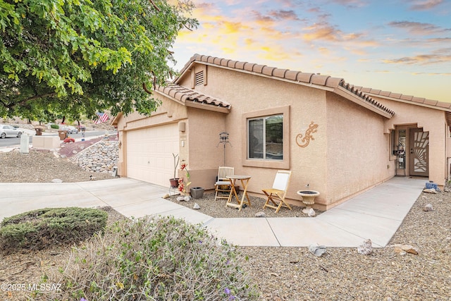 61080 Halter Pl, Saddlebrooke, AZ 85739 - mediterranean / spanish-style house featuring stucco siding, an attached garage, a tile roof, and concrete driveway