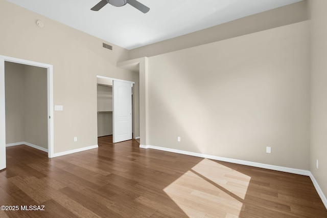 unfurnished bedroom featuring visible vents, baseboards, a ceiling fan, and wood finished floors
