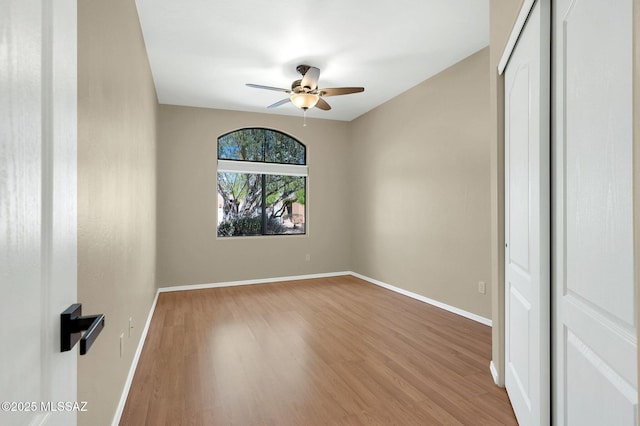 unfurnished room with baseboards, a ceiling fan, and wood finished floors
