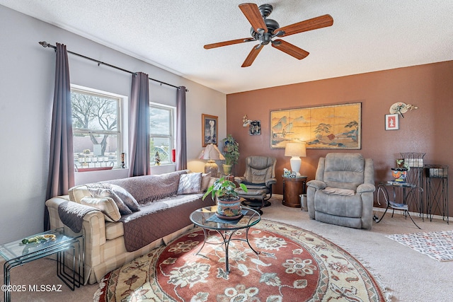 living area featuring baseboards, a textured ceiling, carpet, and a ceiling fan