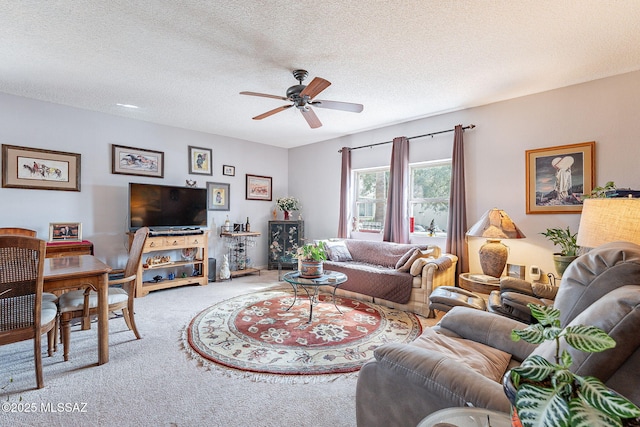 carpeted living area with a textured ceiling and a ceiling fan
