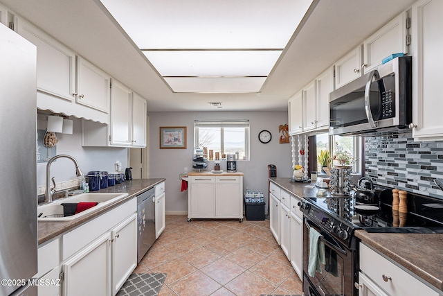 kitchen featuring backsplash, a sink, white cabinetry, and appliances with stainless steel finishes