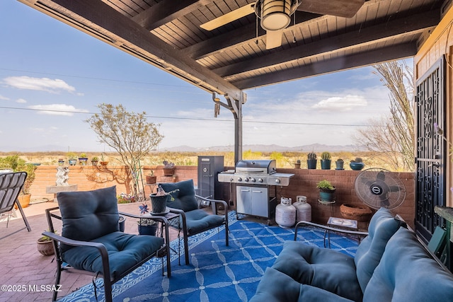 view of patio / terrace with a ceiling fan, area for grilling, a mountain view, and fence
