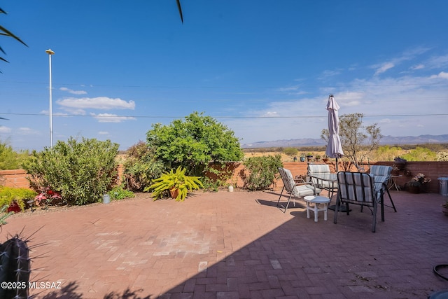 view of patio featuring outdoor dining area and fence