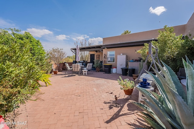 back of house featuring a patio, outdoor dining space, and stucco siding