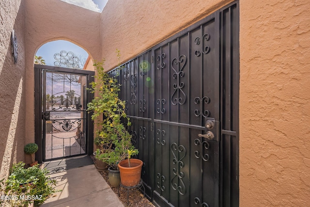 property entrance featuring stucco siding and a gate