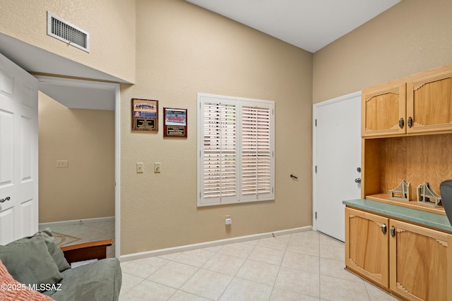 interior space featuring baseboards, light tile patterned flooring, and visible vents