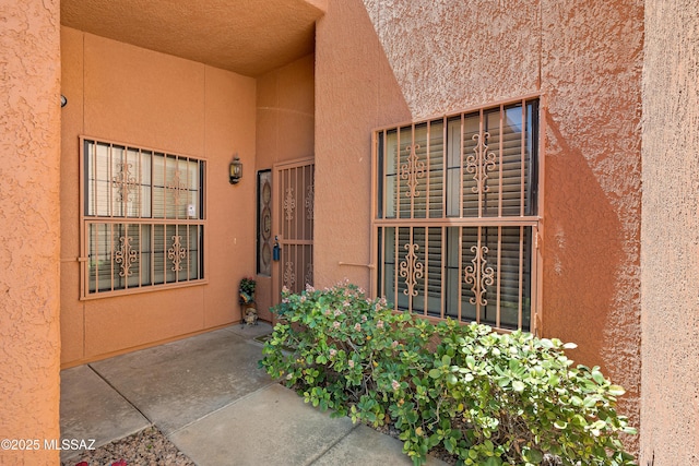 doorway to property featuring stucco siding