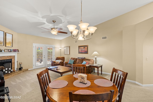dining space featuring baseboards, ceiling fan with notable chandelier, light carpet, and french doors
