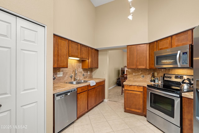 kitchen with light countertops, light tile patterned floors, appliances with stainless steel finishes, and a sink