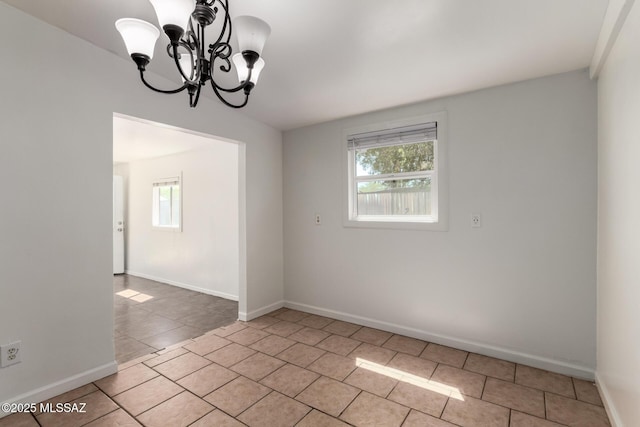 5914 E Beverly St, Tucson, AZ 85711 - spare room with light tile patterned floors, baseboards, plenty of natural light, and an inviting chandelier