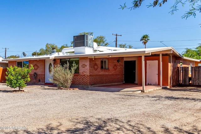 5914 E Beverly St, Tucson, AZ 85711 - rear view of property with brick siding, fence, cooling unit, and a carport