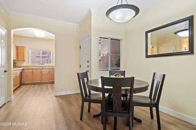 7050 E Sunrise Dr Unit 1104, Tucson, AZ 85750 - dining area featuring light wood-style floors, arched walkways, ornamental molding, and baseboards