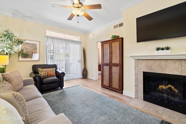 7050 E Sunrise Dr Unit 1104, Tucson, AZ 85750 - living area with ornamental molding, a ceiling fan, a fireplace, baseboards, and wood finished floors