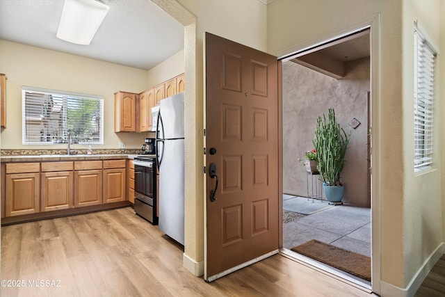 7050 E Sunrise Dr Unit 1104, Tucson, AZ 85750 - kitchen featuring stainless steel appliances, light wood-type flooring, light countertops, and light brown cabinets