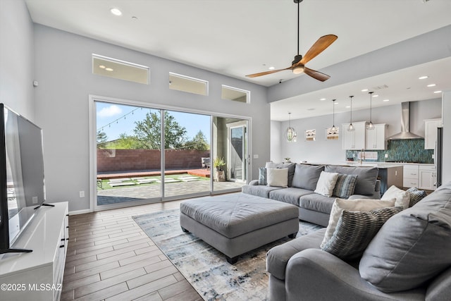 7415 W Cactus Flower Pass, Marana, AZ 85658 - living room with recessed lighting, a ceiling fan, a high ceiling, and wood finished floors