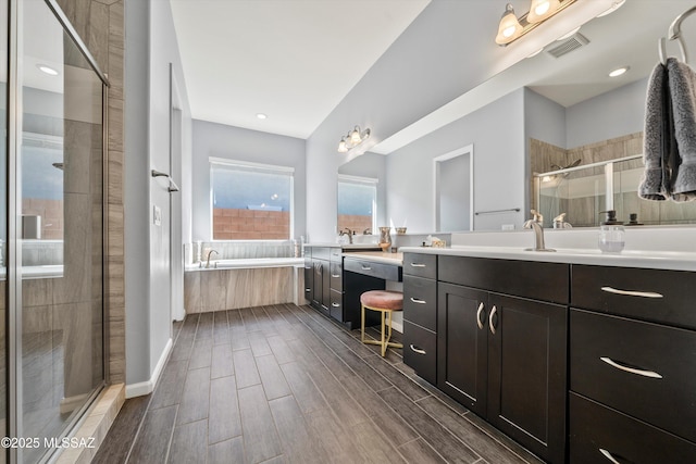 7415 W Cactus Flower Pass, Marana, AZ 85658 - bathroom featuring a garden tub, a stall shower, vanity, and wood finish floors