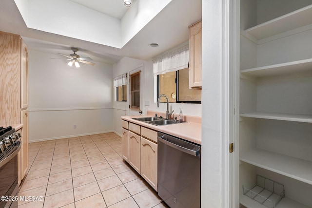 kitchen featuring light countertops, a sink, a ceiling fan, dishwasher, and gas range oven
