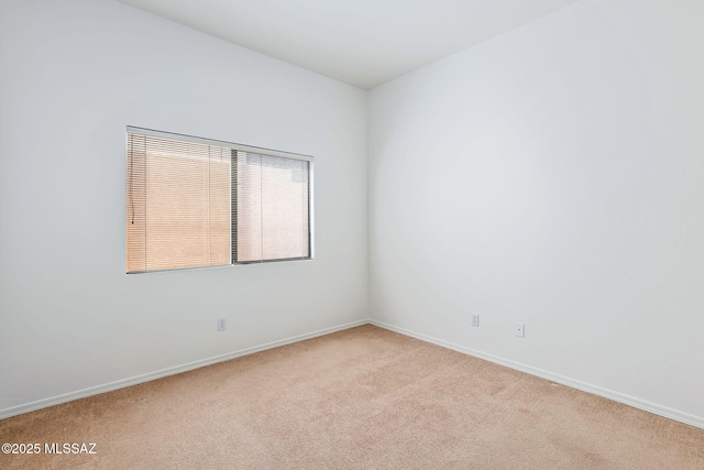 spare room with light carpet and baseboards