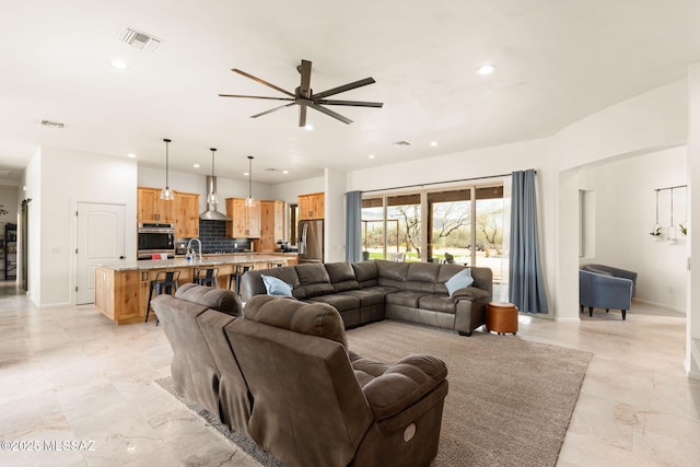 living room featuring visible vents, baseboards, a ceiling fan, and recessed lighting