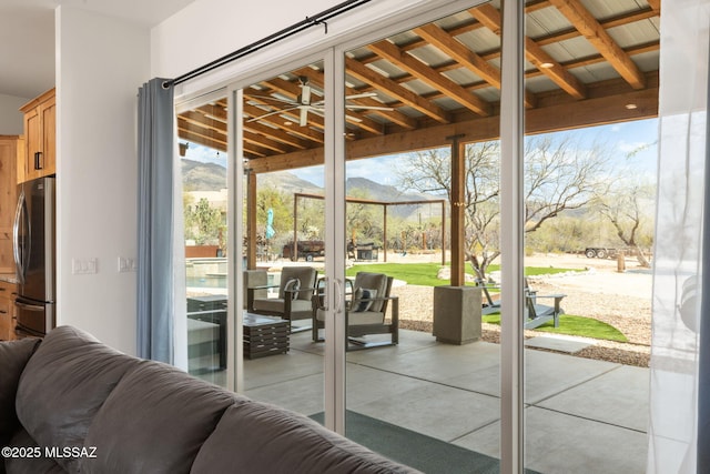 doorway with a mountain view, a wealth of natural light, and expansive windows
