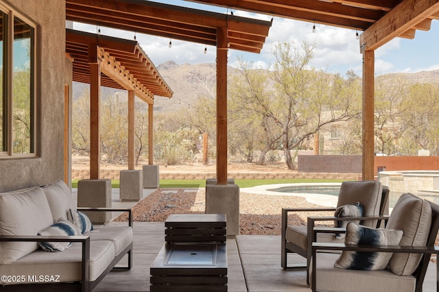 view of patio with a mountain view, outdoor lounge area, and fence