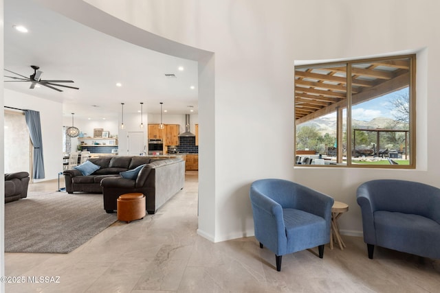 living area featuring ceiling fan, recessed lighting, and baseboards
