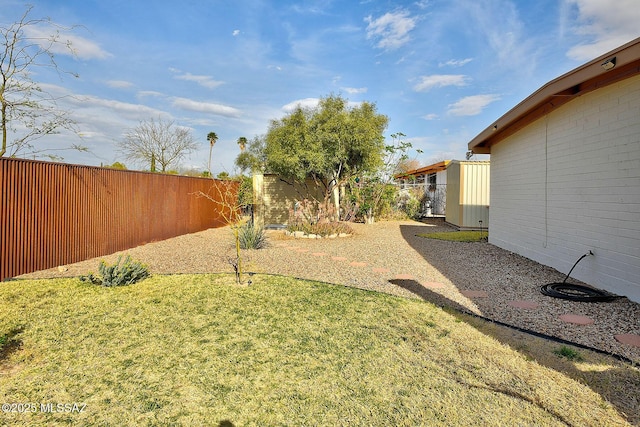 view of yard with a fenced backyard and an outbuilding