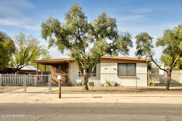 view of front of home with a fenced front yard, a carport, brick siding, and concrete driveway