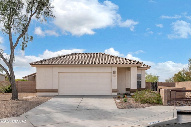 mediterranean / spanish-style house with stucco siding, a tile roof, fence, and driveway