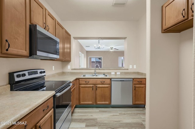 kitchen featuring light countertops, an inviting chandelier, a sink, visible vents, and appliances with stainless steel finishes