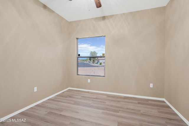 spare room with a ceiling fan, baseboards, and light wood-style flooring