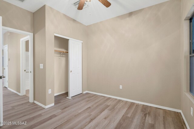unfurnished bedroom featuring baseboards, visible vents, a closet, and light wood-style floors