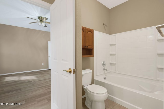 bathroom with toilet, shower / tub combination, wood finished floors, baseboards, and ceiling fan