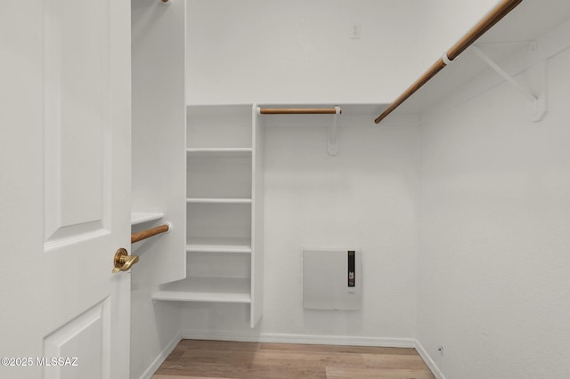 walk in closet with wood finished floors
