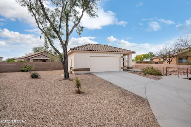 mediterranean / spanish-style home featuring stucco siding, fence, a tiled roof, driveway, and a garage