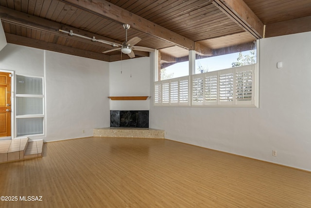 unfurnished living room featuring wooden ceiling, ceiling fan, and beam ceiling