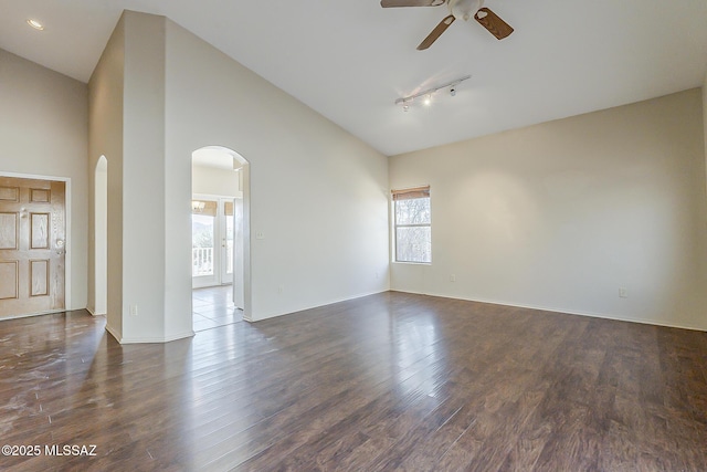 2525 N Camino Reloj, Green Valley, AZ 85614 - empty room with arched walkways, ceiling fan, dark wood-type flooring, track lighting, and baseboards