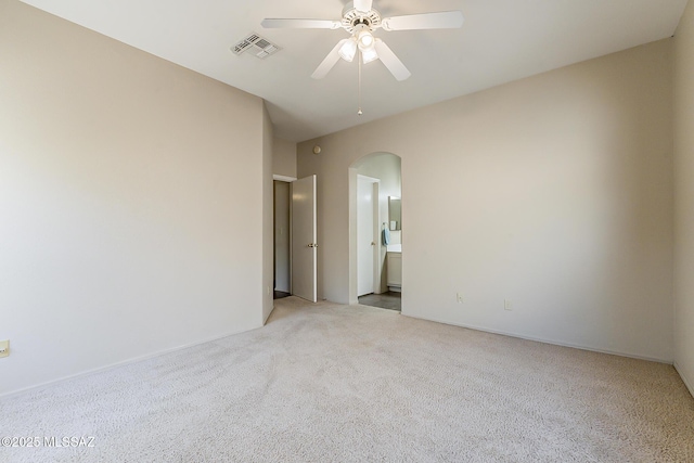 2525 N Camino Reloj, Green Valley, AZ 85614 - spare room with arched walkways, light carpet, and a ceiling fan
