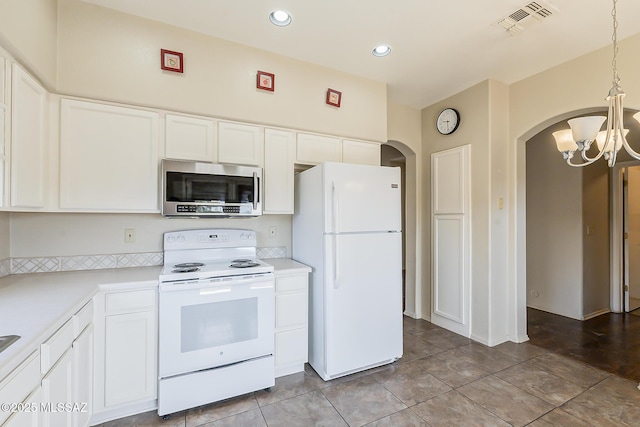 2525 N Camino Reloj, Green Valley, AZ 85614 - kitchen featuring white appliances, arched walkways, a chandelier, light countertops, and white cabinets